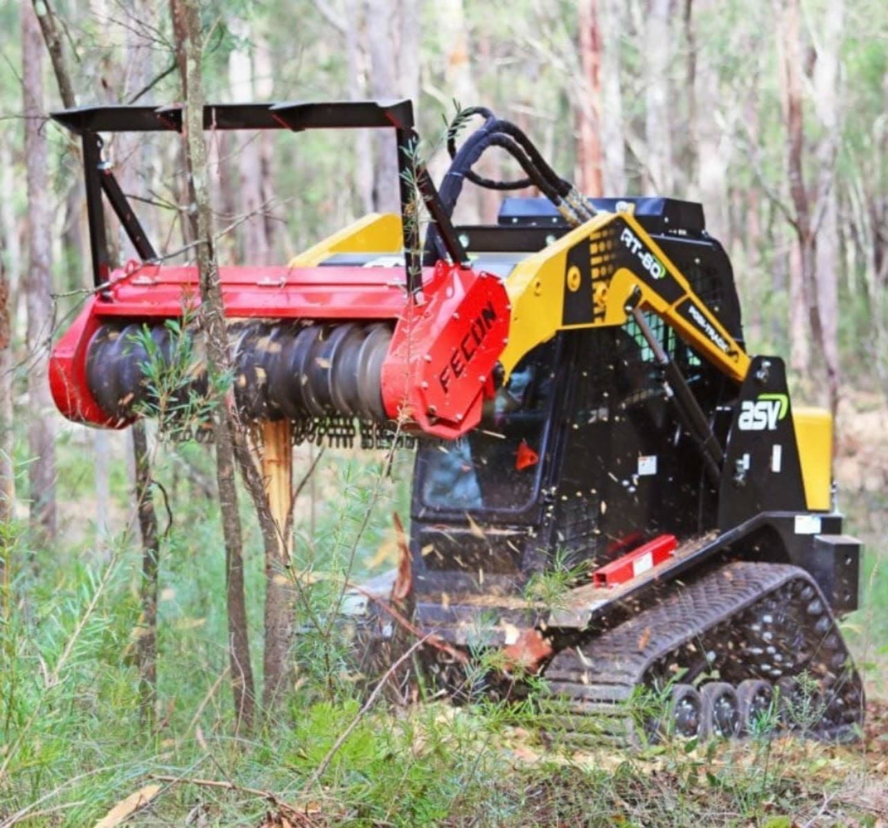 Black forestry mulcher on tracks clearing brush in a wooded area