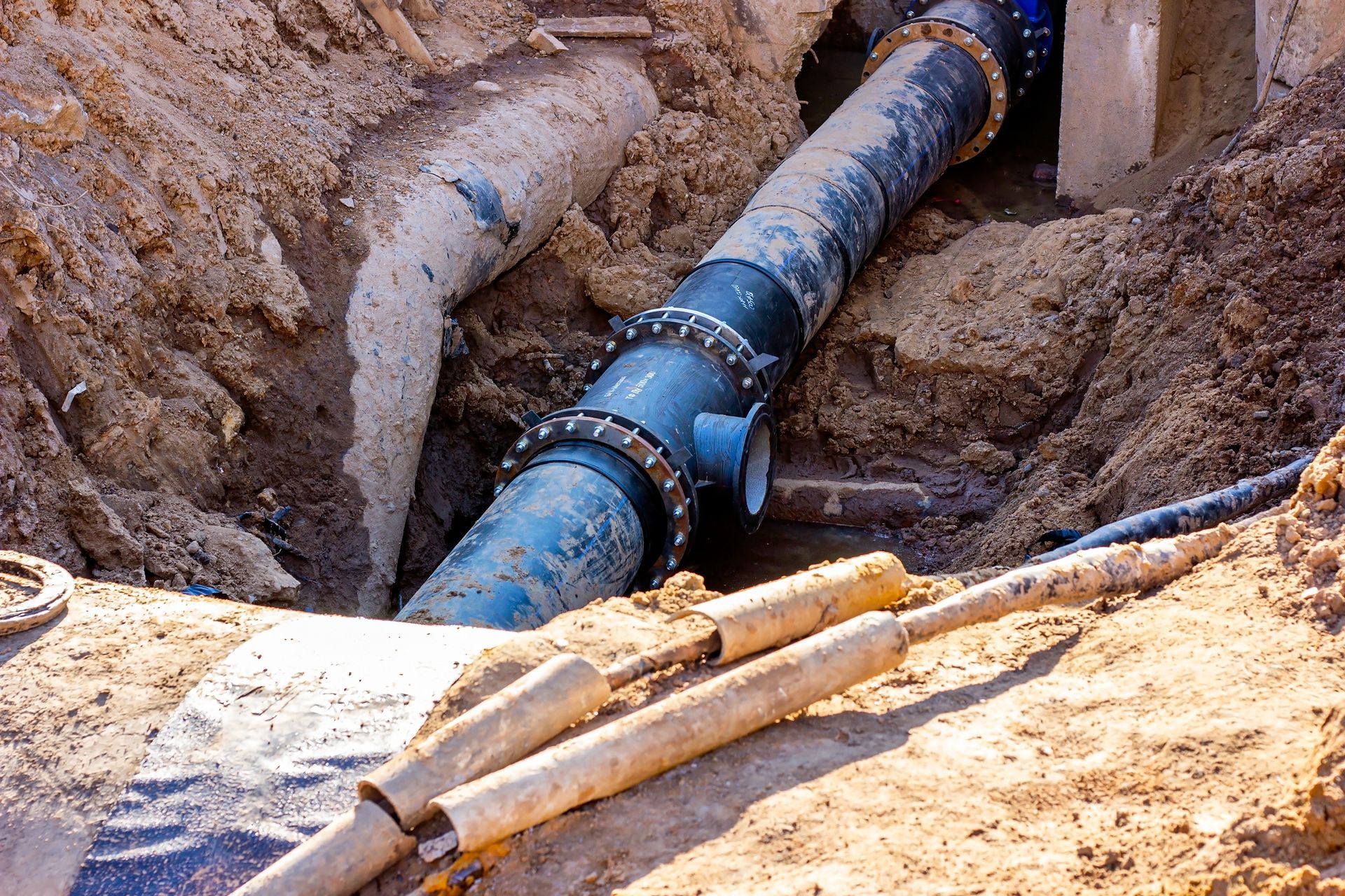 Blue water pipe in a dirt trench during underground repair work