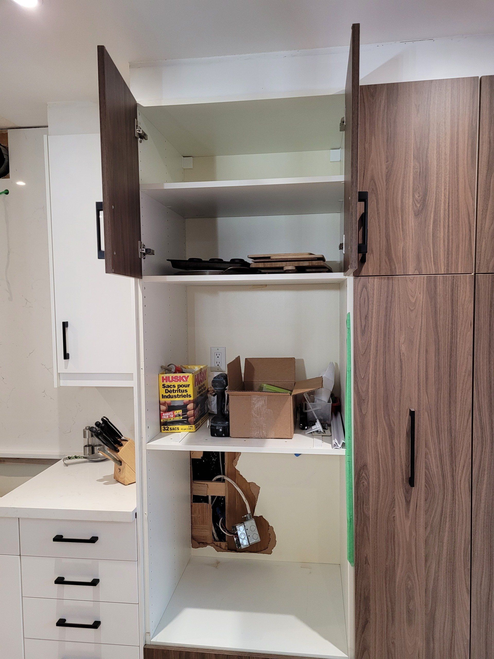 An empty pantry in a kitchen with the doors open