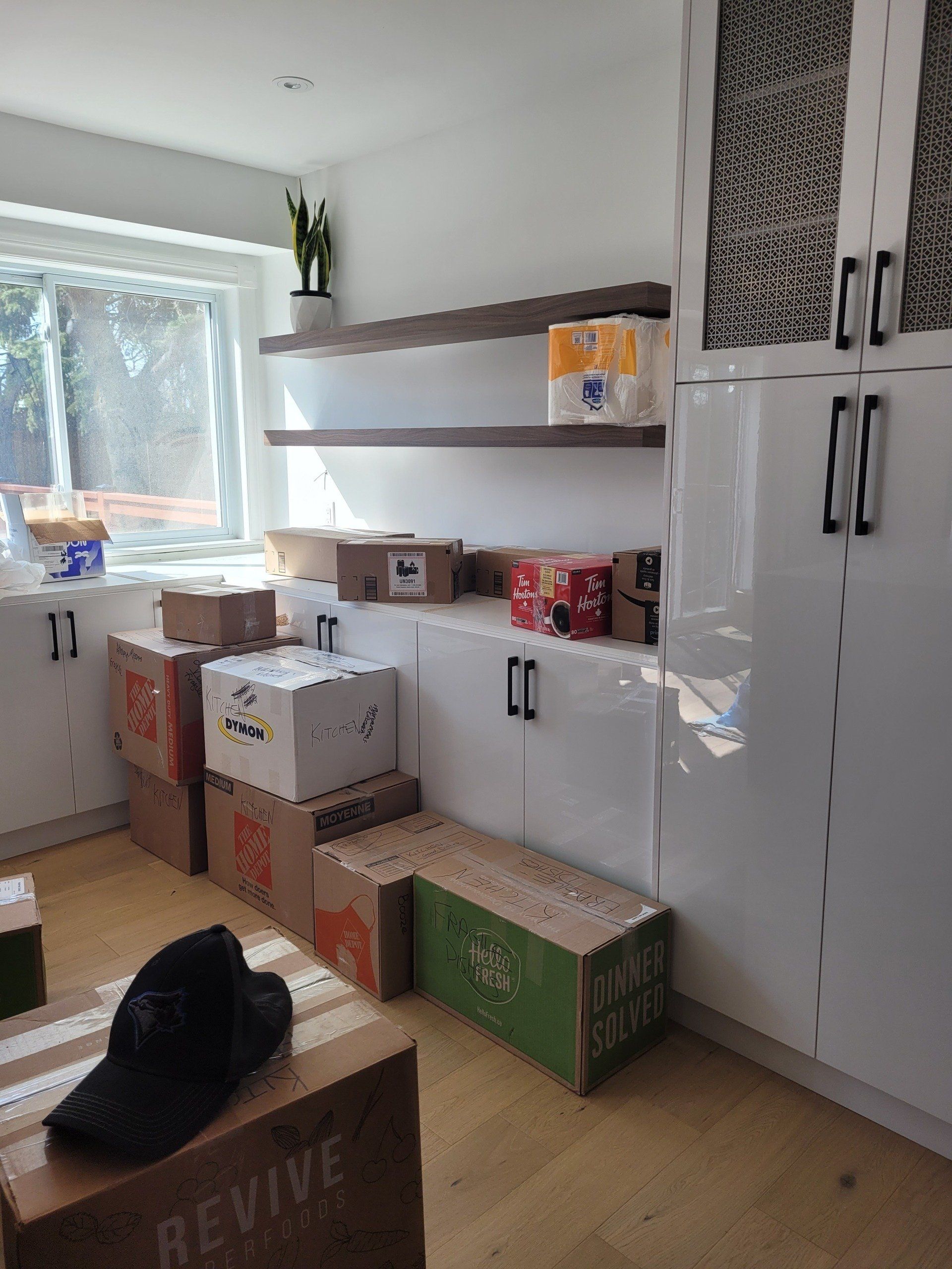 A room with boxes stacked on top of each other and a hat on a box that says revine.