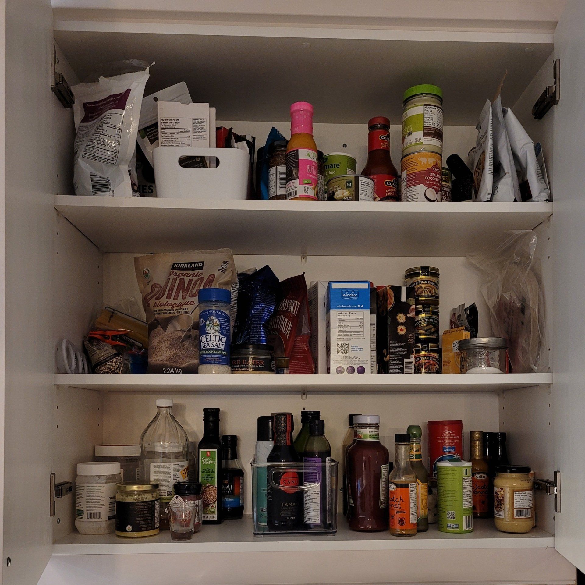 A pantry with a bag of pinto beans on the top shelf