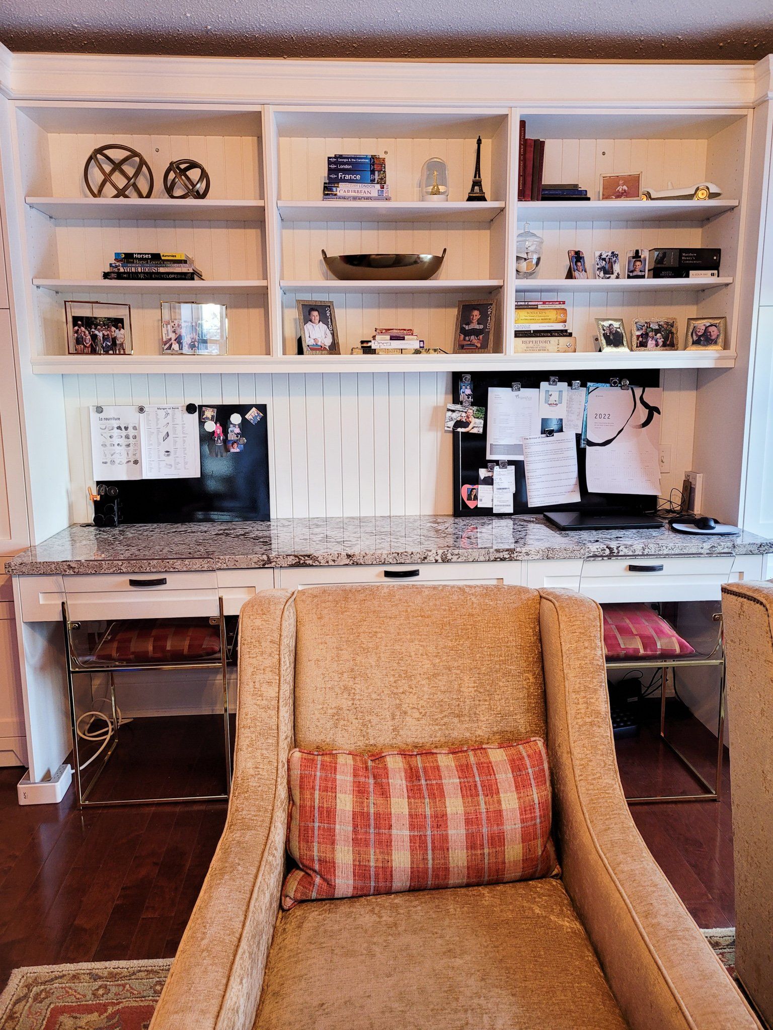 A living room with two chairs and a desk with a computer on it