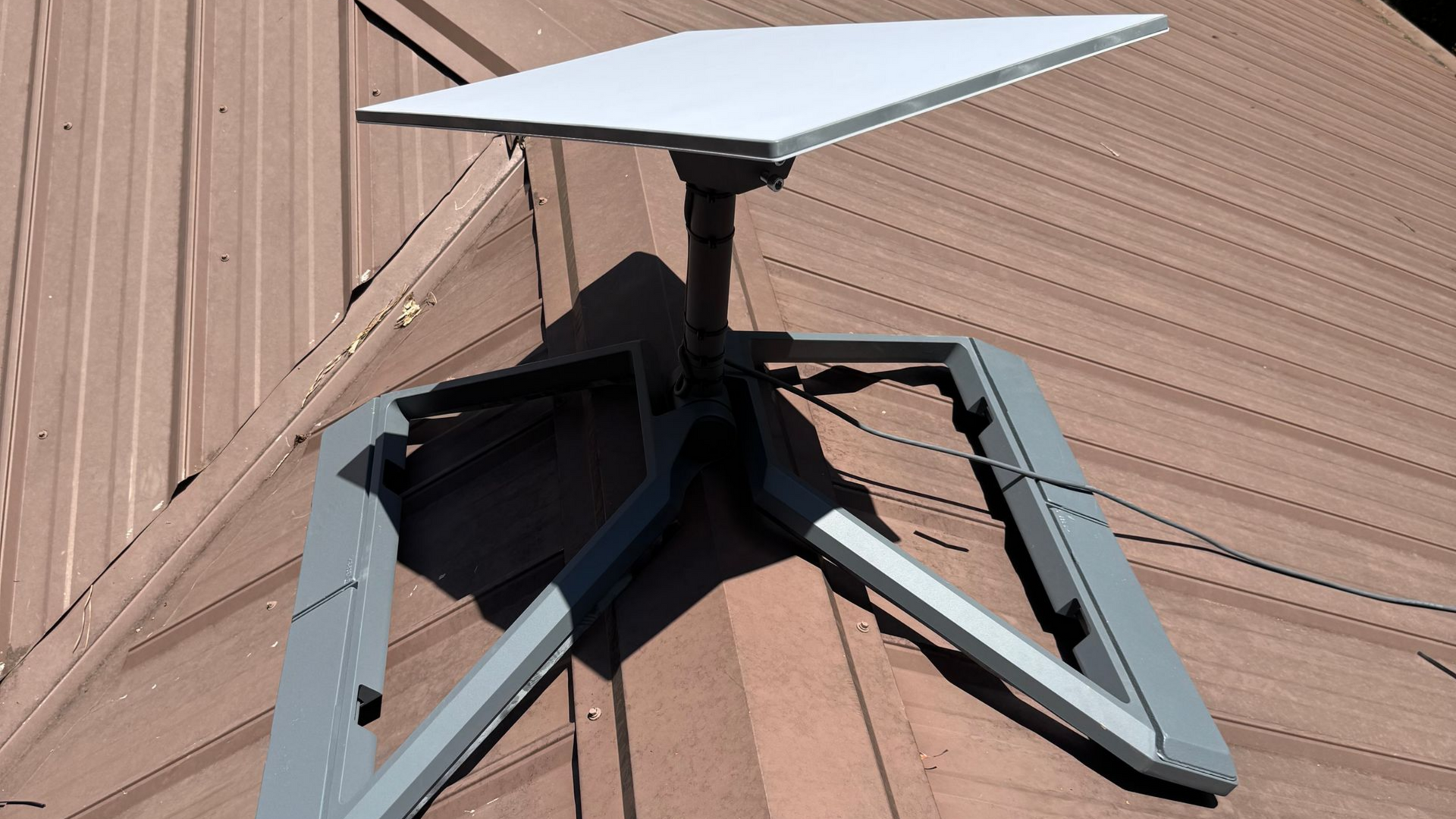 Gray rooftop solar vent with a white cap on a shingled roof