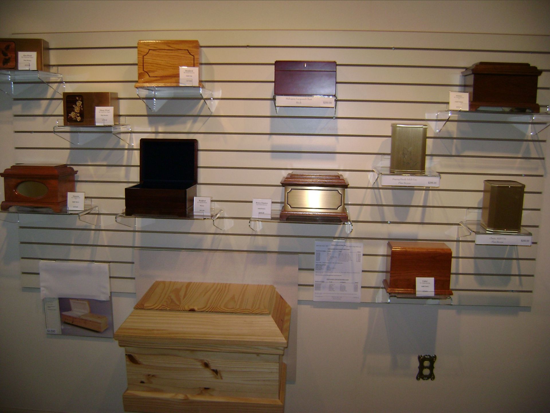 Various wooden birdhouses and small display boxes arranged on a slatwall in a shop display.