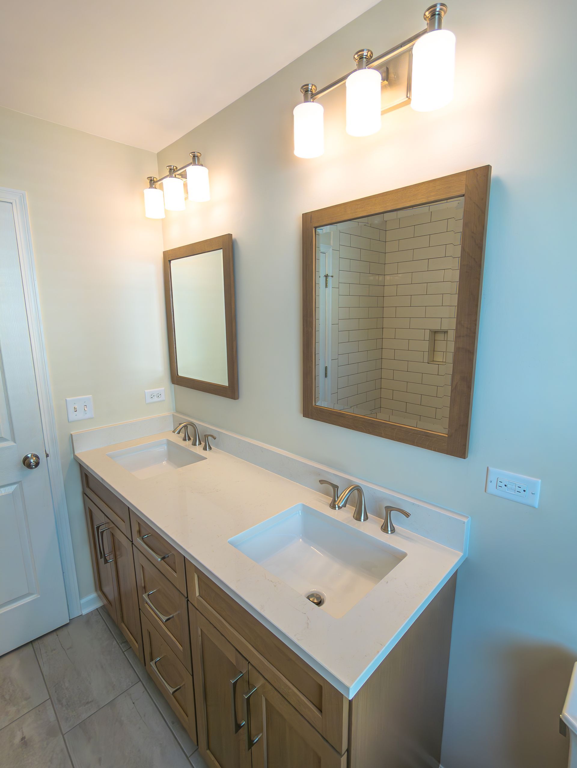 A bathroom with two sinks and two mirrors