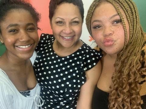 three women are posing for a picture and one of them is wearing a polka dot dress