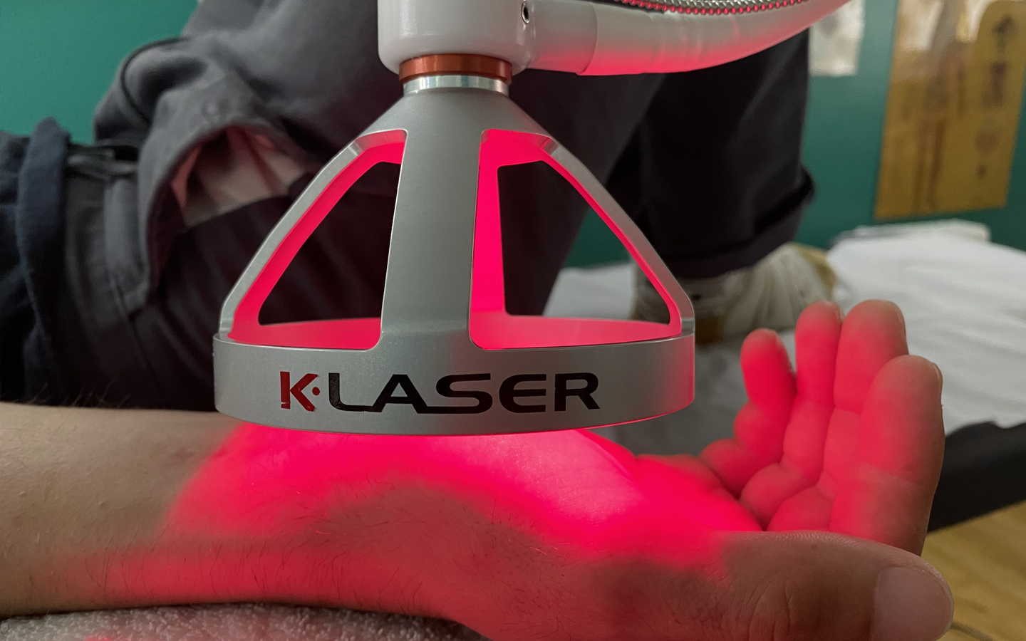 A person is getting k-laser therapy to their hand