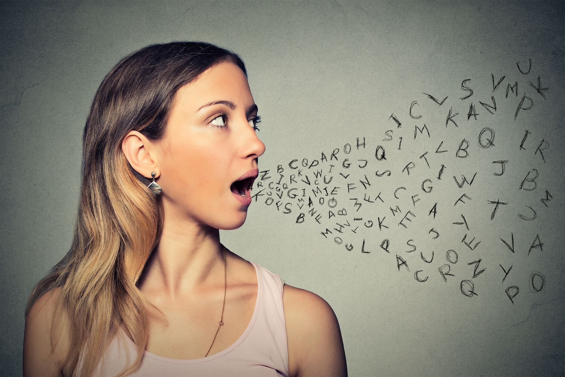 A woman is talking with letters coming out of her mouth.