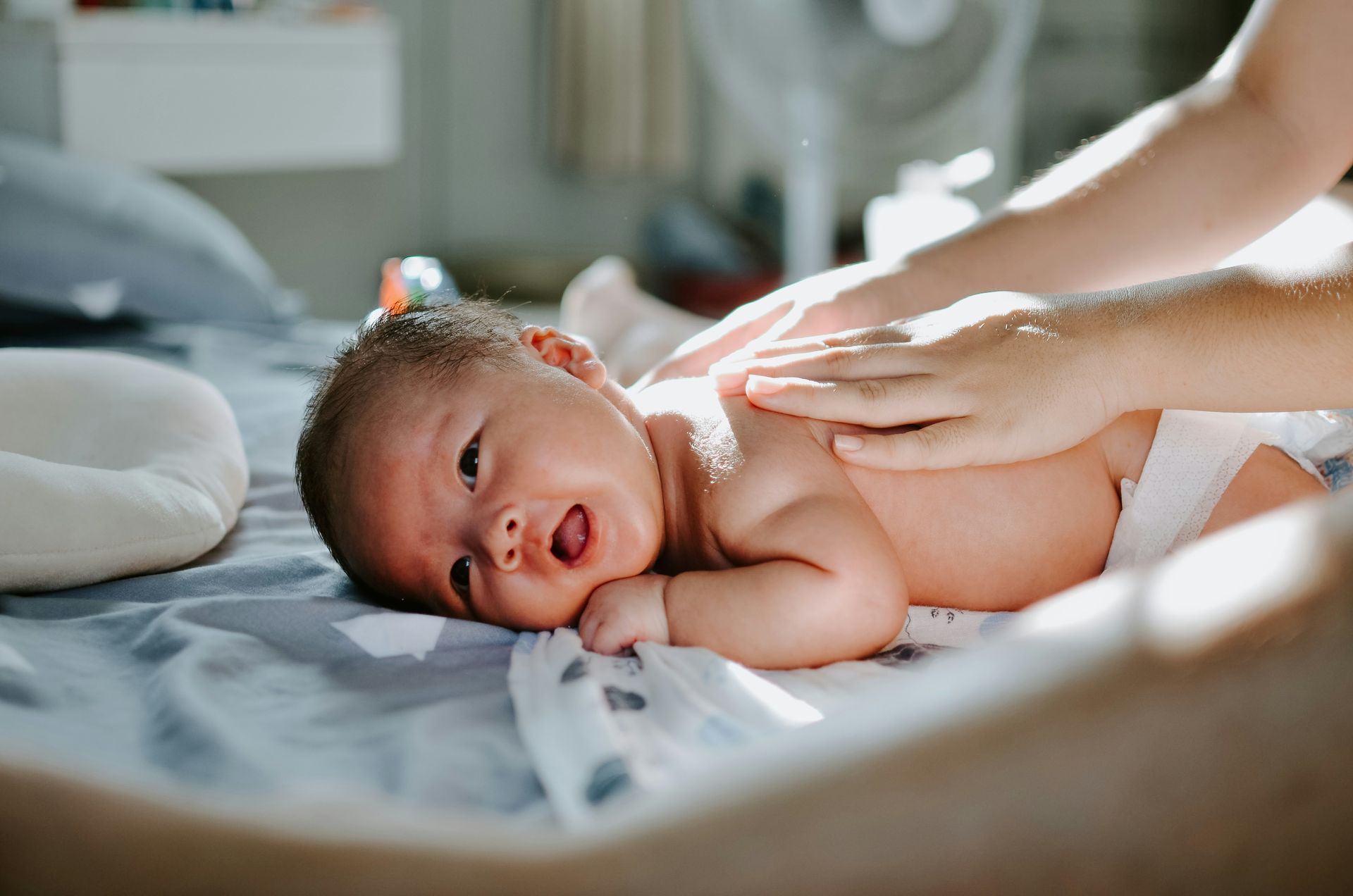 Baby on stomach, receiving gentle touch to their back