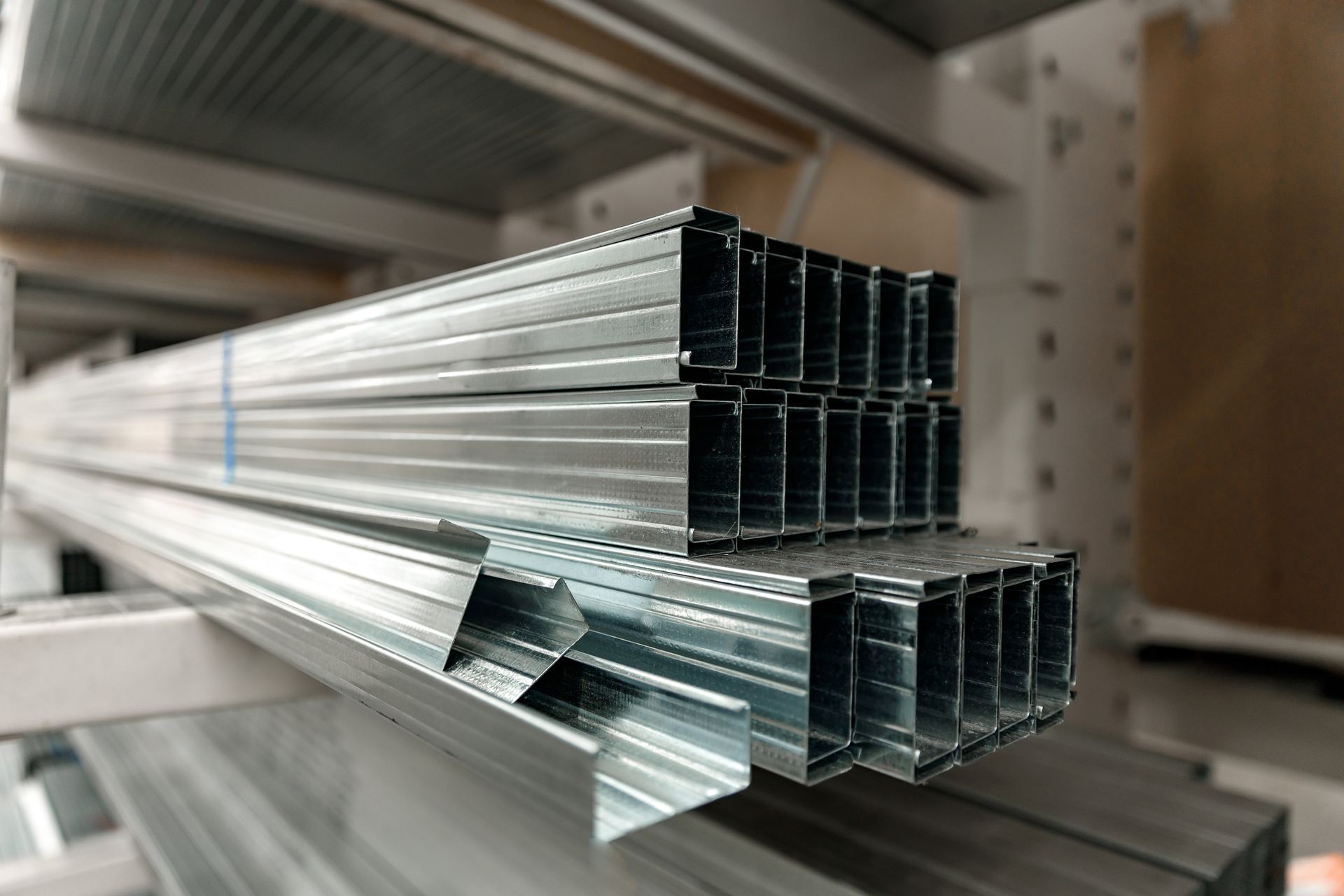 Metal framing studs stacked on a shelf in a store, ready for construction use.