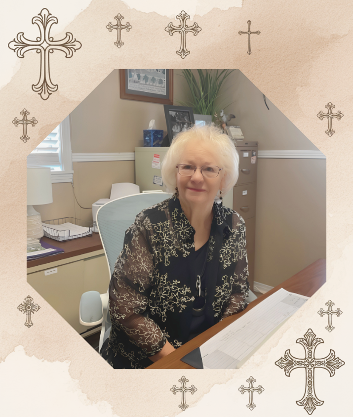 Woman seated at a desk in an office, smiling, with decorative cross border.