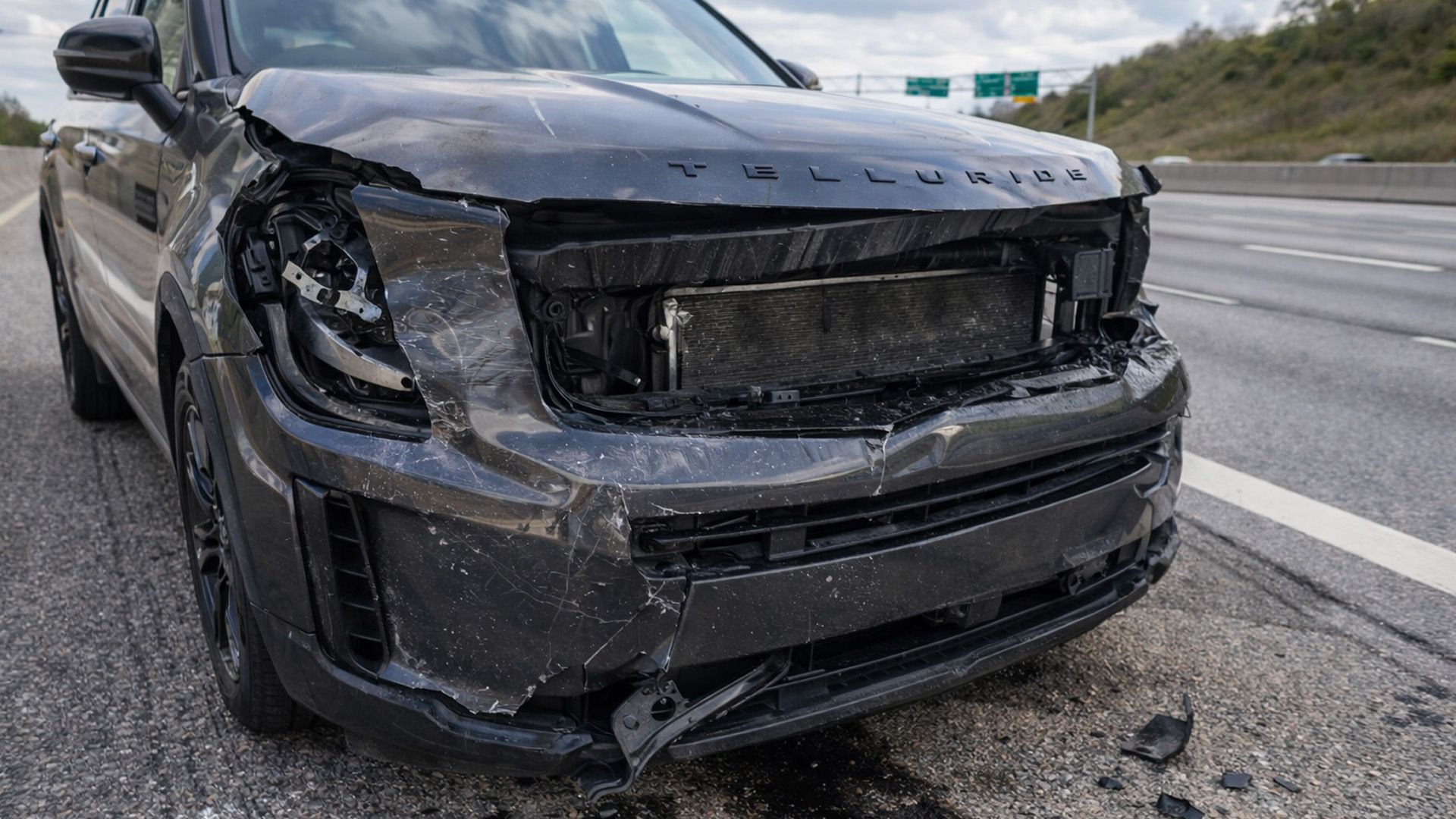 Front passenger side bumper of a black SUV on a Fort Worth highway is crumpled from car accident