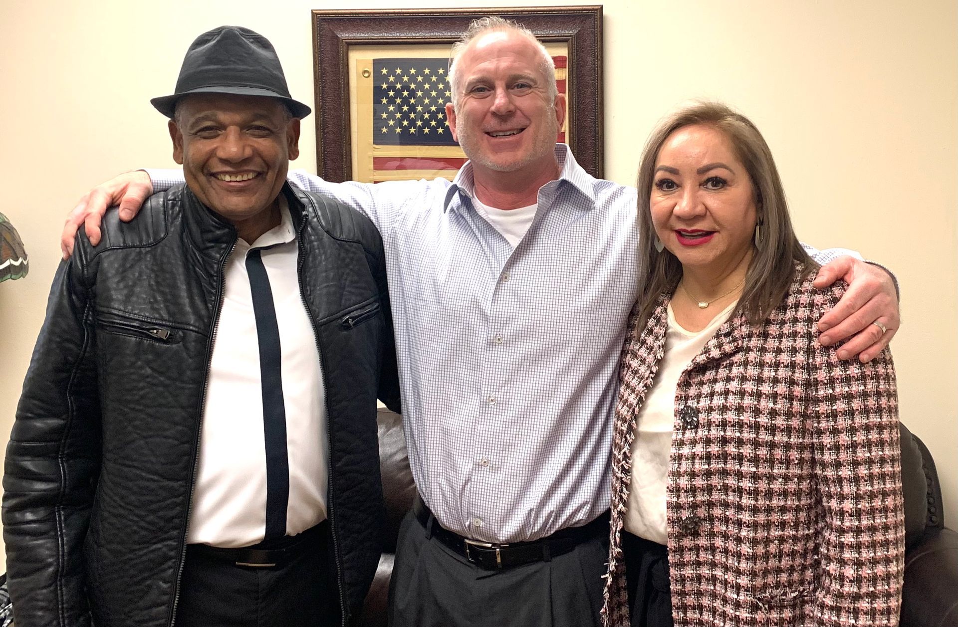 A man and two women are posing for a picture together.