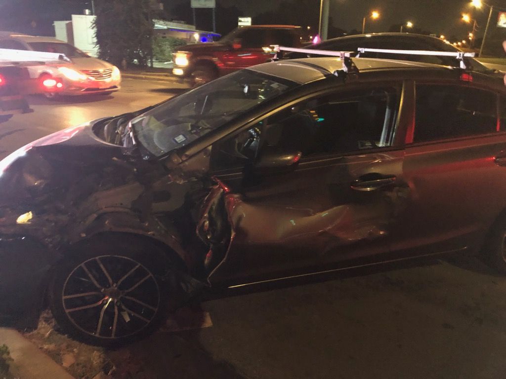 A damaged car is parked on the side of the road