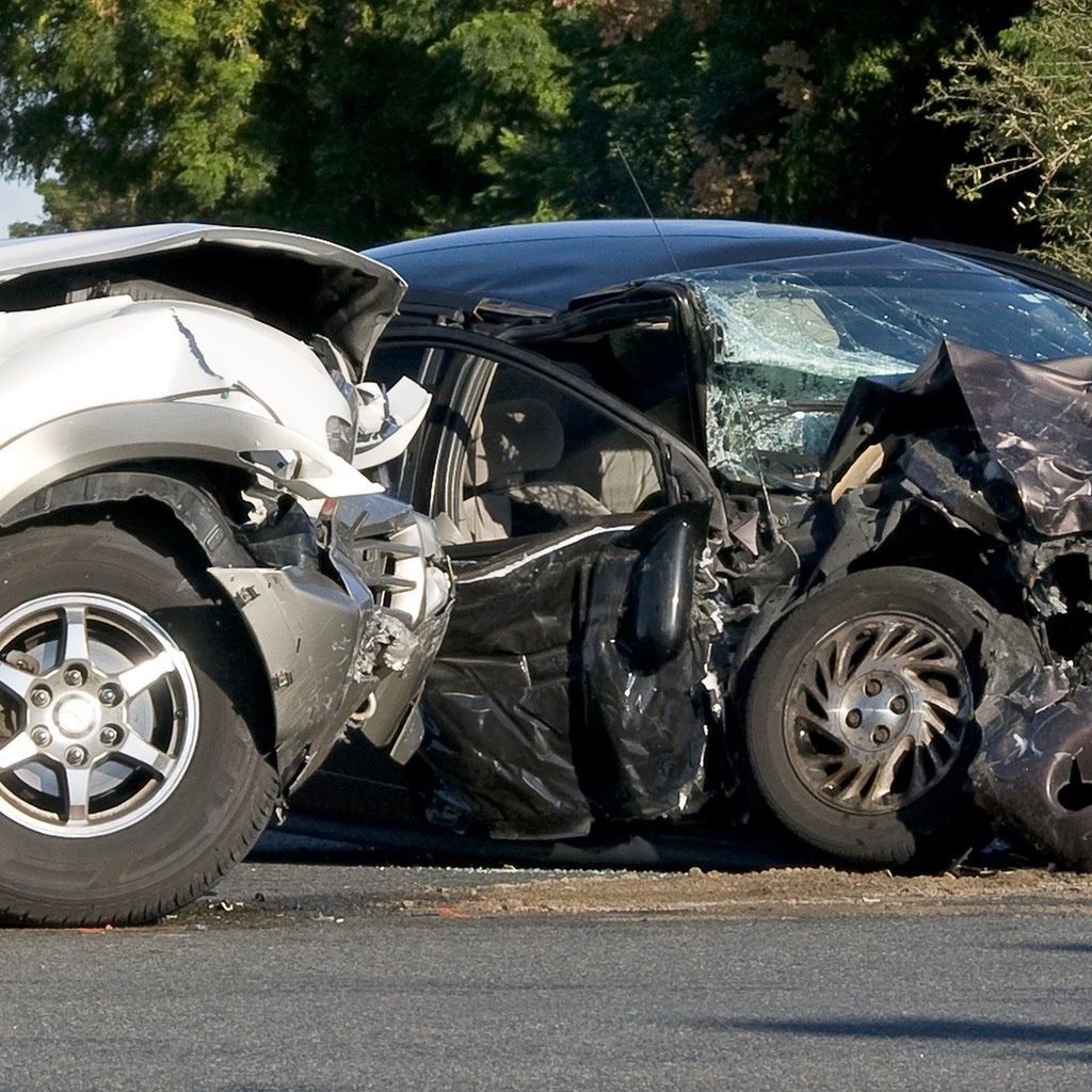 Two smashed vehicles in the middle of an intersection after a negligent driver runs a red light.