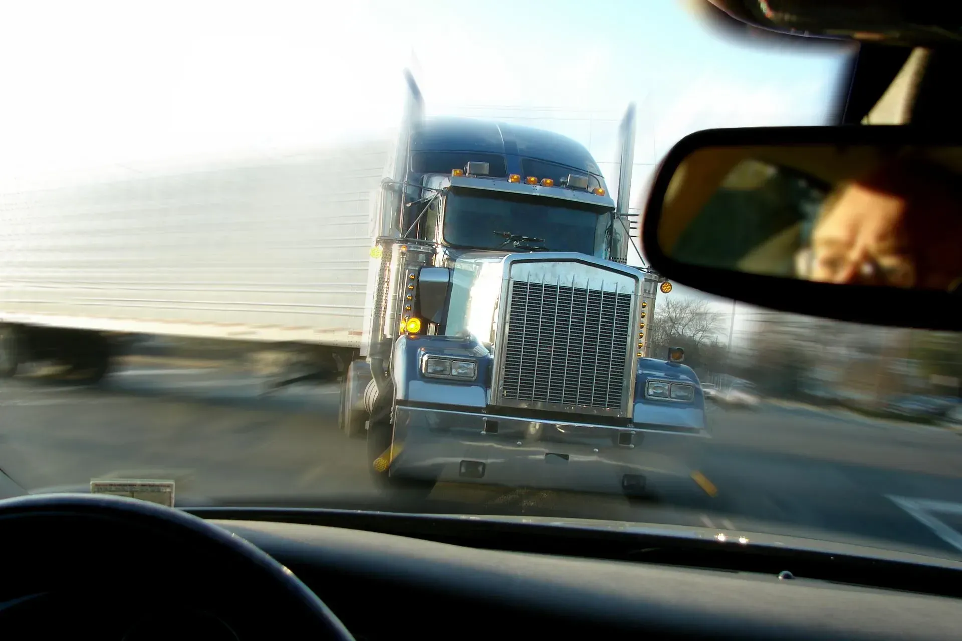 18-Wheeler truck heading straight for a passenger car on a highway. 