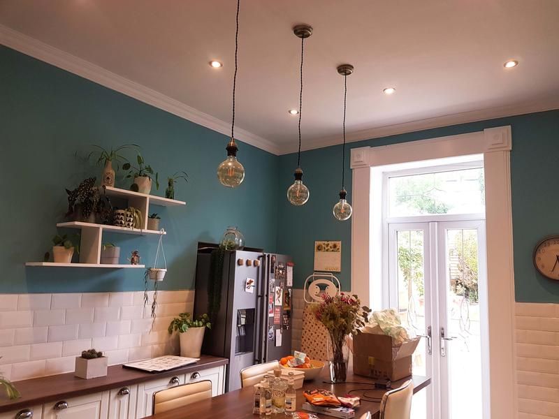 A picture of a kitchen painted turquoise with white tiles by Elite Edge Painters and Decorators Manchester