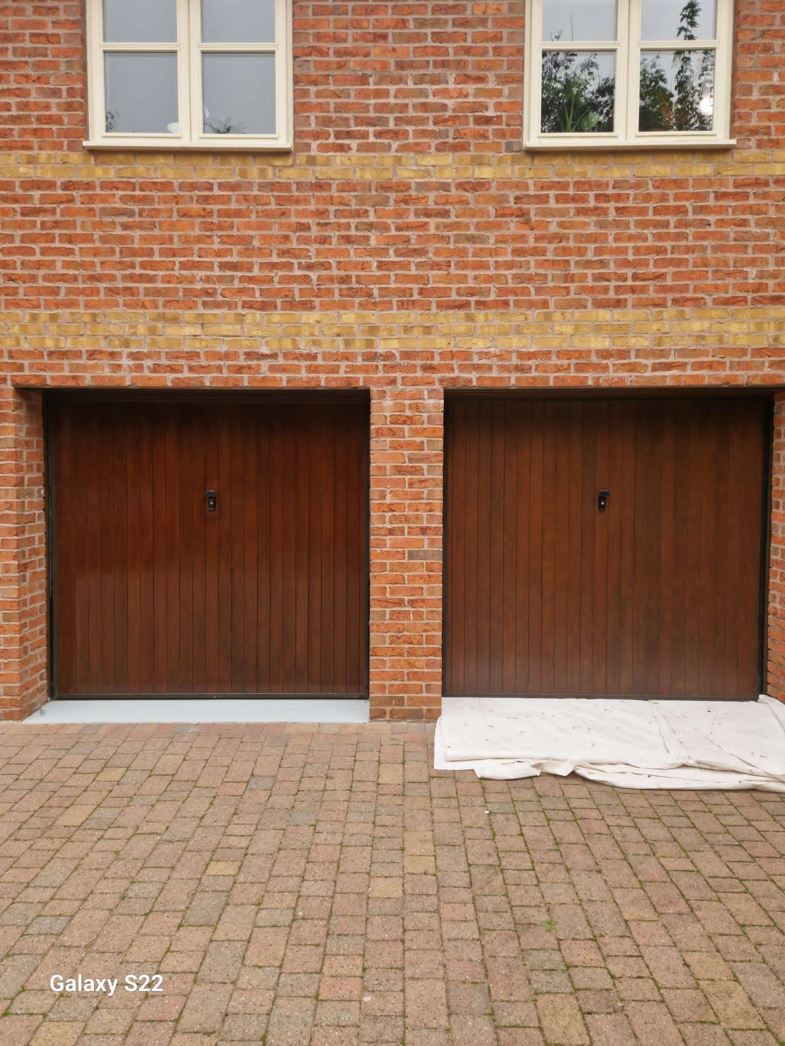 A picture of garage doors freshly painted brown on a property in Manchester by Elite Edge Painters and Decorators Manchester