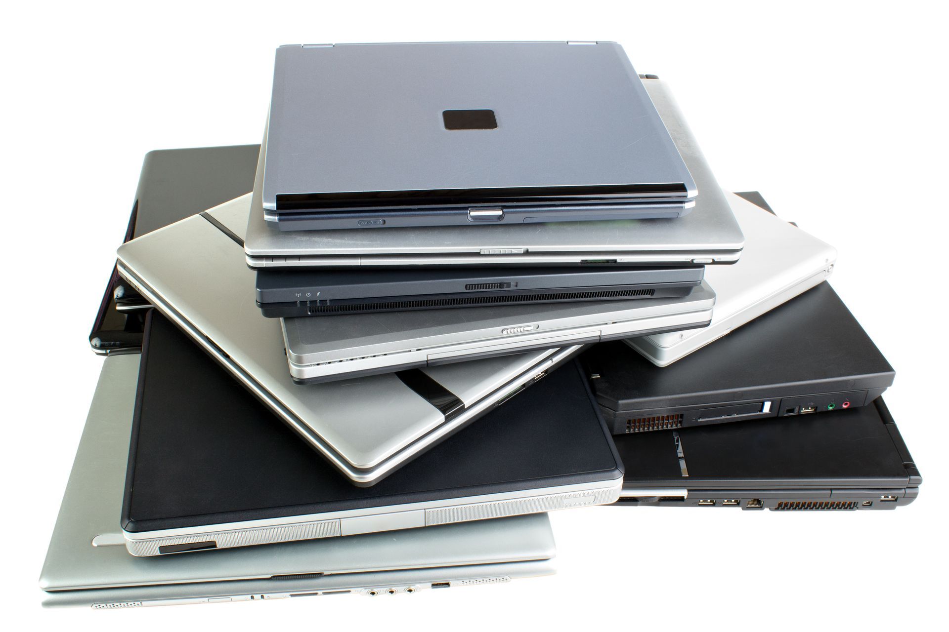 A stack of various pre-owned laptop computers in different colors and brands