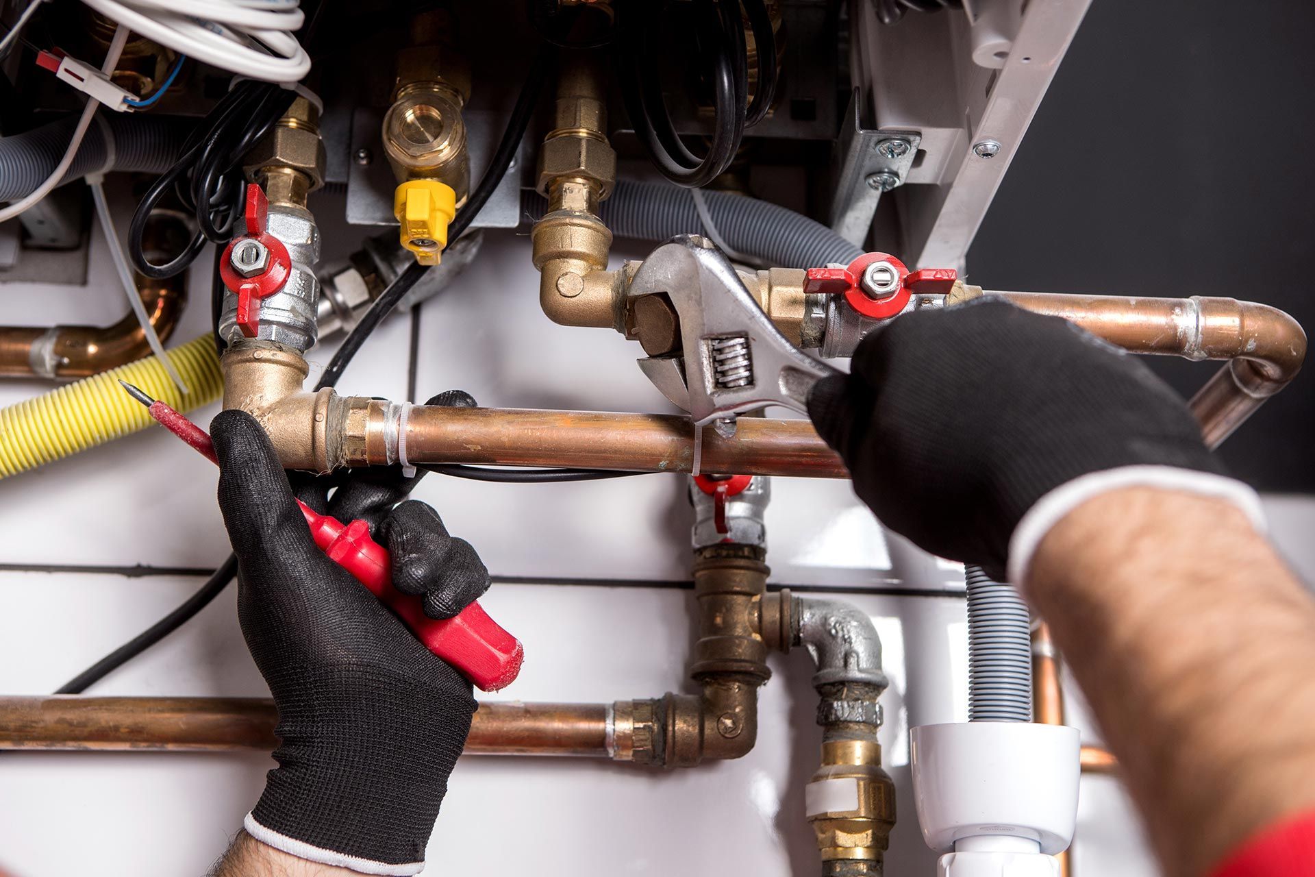 Plumbing repair on copper pipes using wrench and tool inside mechanical system unit service repairs. Plumbing repair on copper pipes using wrench and tool inside mechanical system unit service repairs.