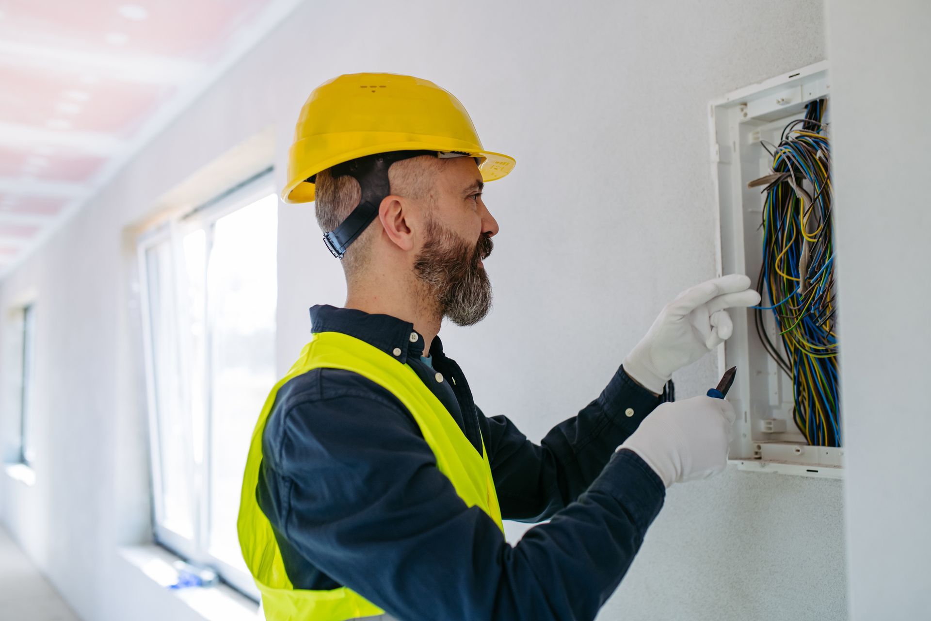 An electrical contractor inspecting connections in an electrical panel An electrical contractor inspecting connections in an electrical panel