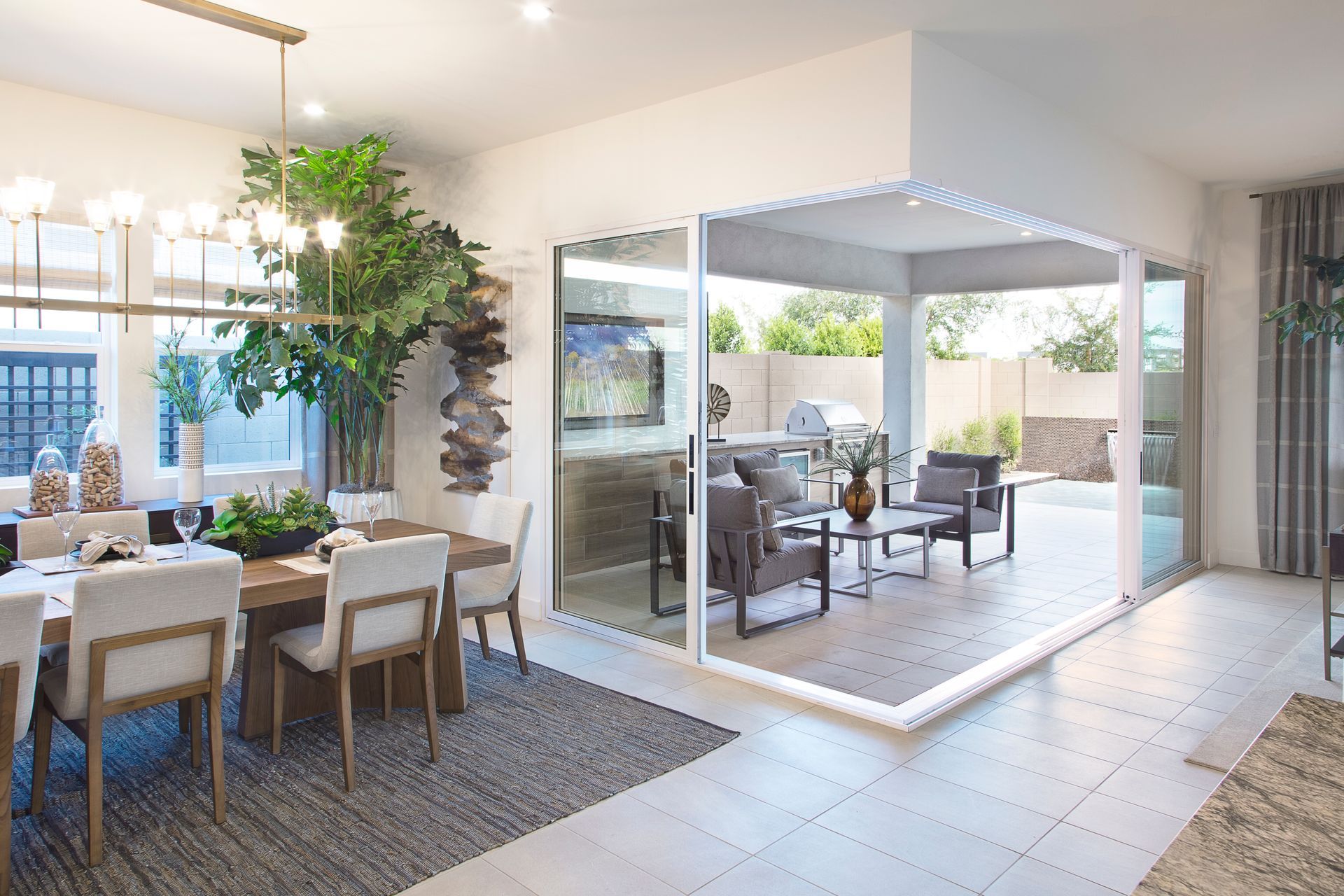 Bright modern dining room with sliding doors opening to a covered patio seating area