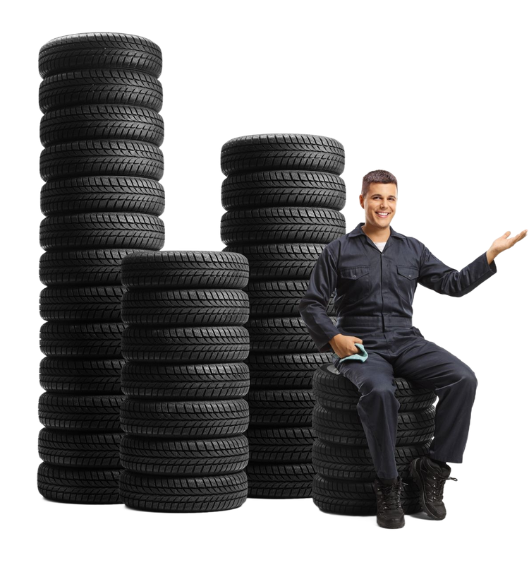 Stacks of black tires beside a seated man in dark clothing, gesturing with one hand on a white background