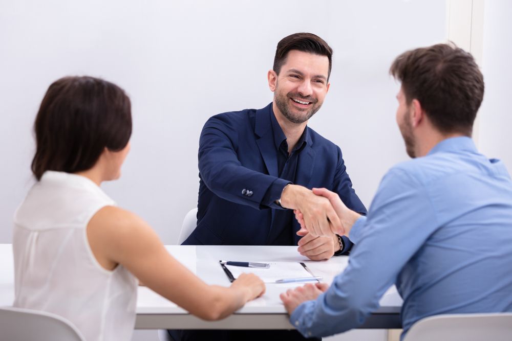 A Lawyer and a Client Are Shaking Hands While Sitting at a Table — O'Reilly & Sochacki Lawyers in Murwillumbah, NSW
