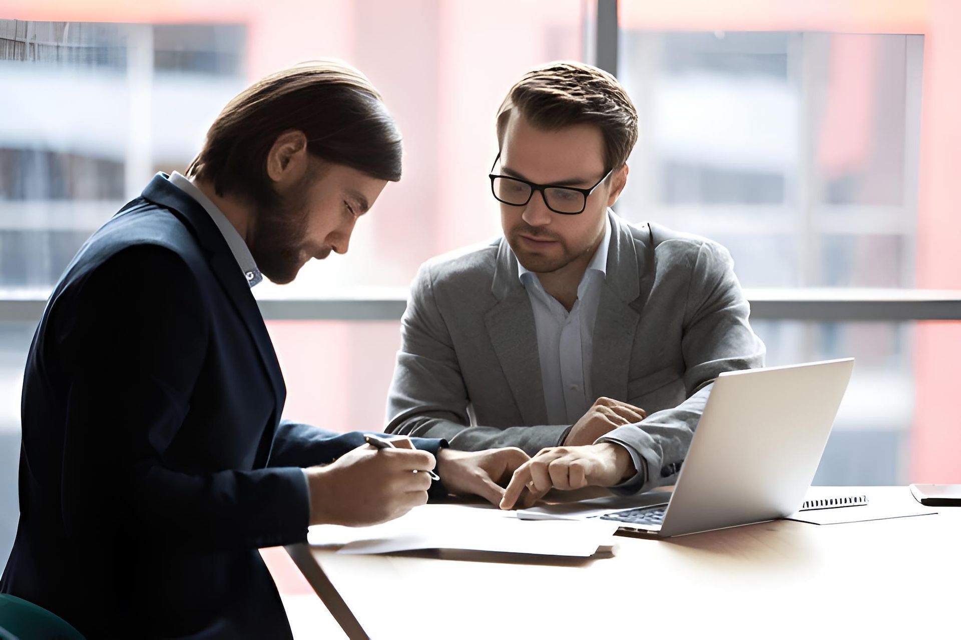 Two Men Are Sitting at a Table With a Laptop — O'Reilly & Sochacki Lawyers in Murwillumbah, NSW