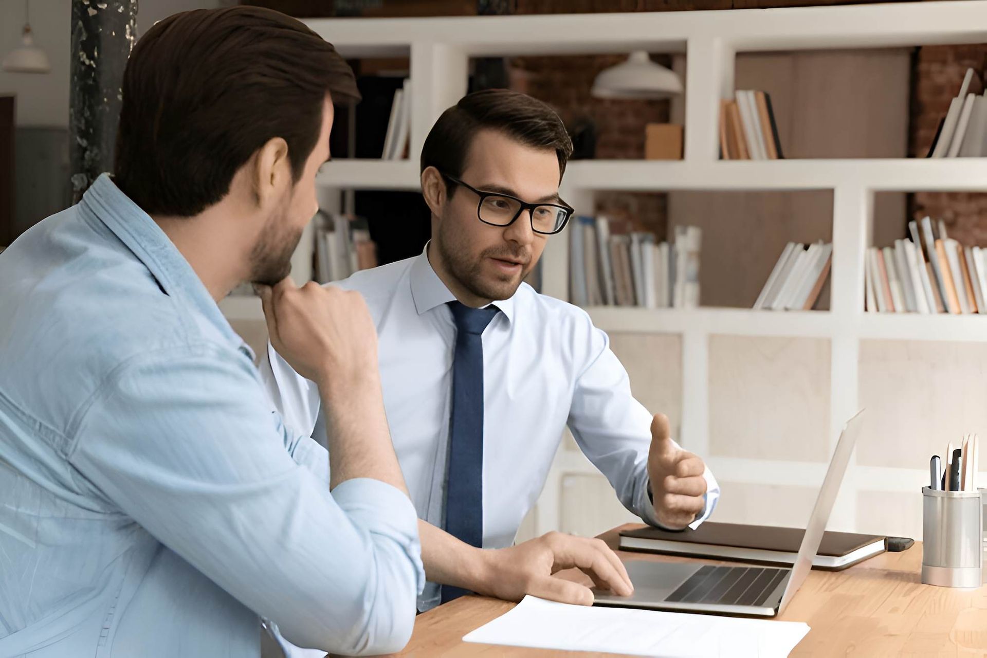 Two Men Are Sitting at a Table Looking at a File on Laptop — O'Reilly & Sochacki Lawyers in Murwillumbah, NSW