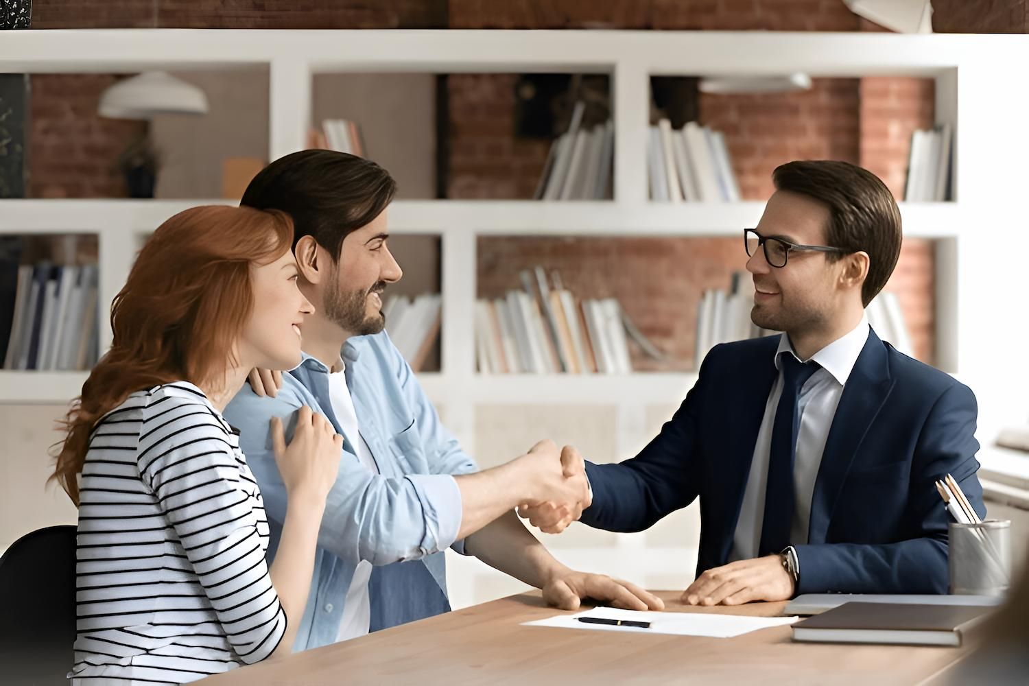 A Man and Woman Are Shaking Hands With a Lawyer — O'Reilly & Sochacki Lawyers in Murwillumbah, NSW