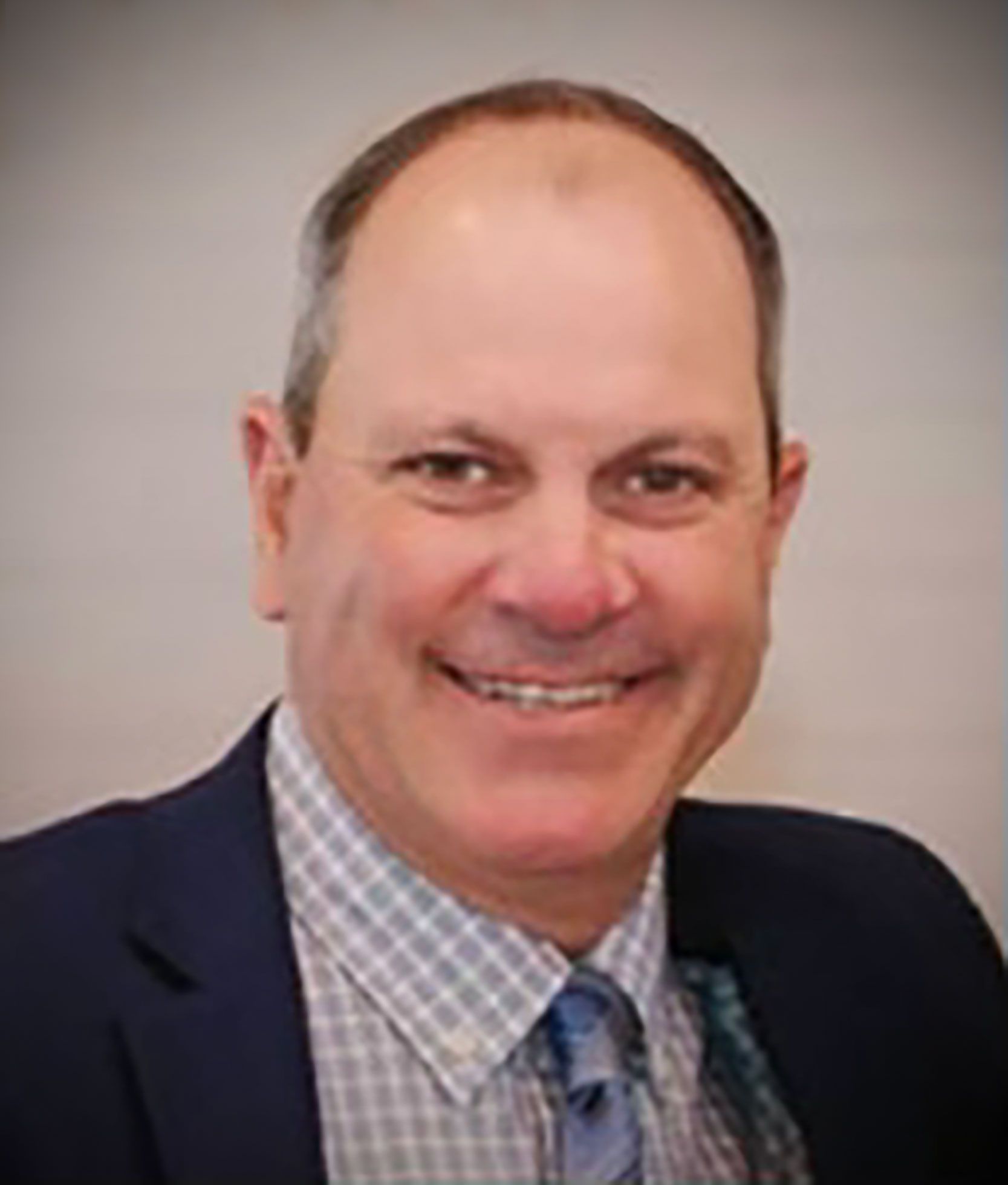 Scott Maxwell in a suit and tie is smiling for the camera .