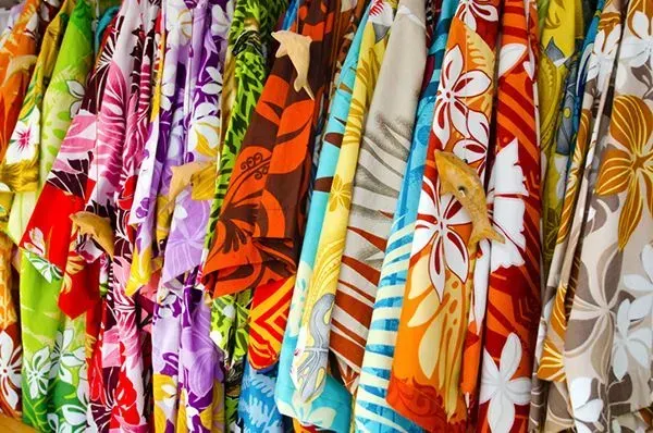 Colorful patterned Hawaiian shirts hanging in a row on a clothing rack