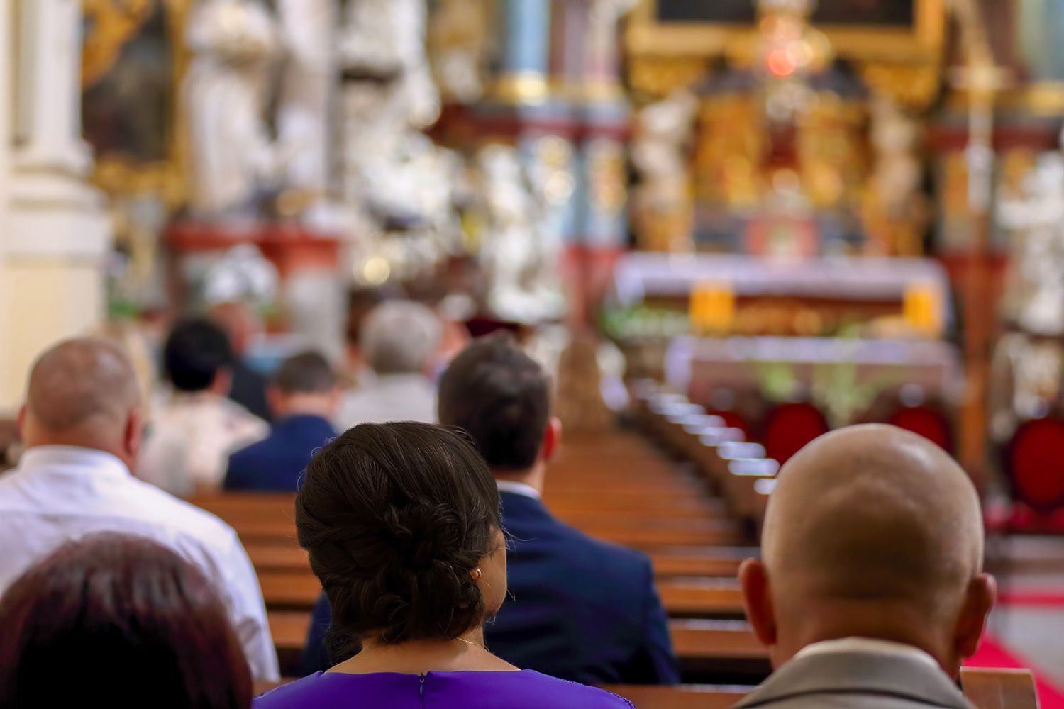 People seated in a church, facing the altar during a service