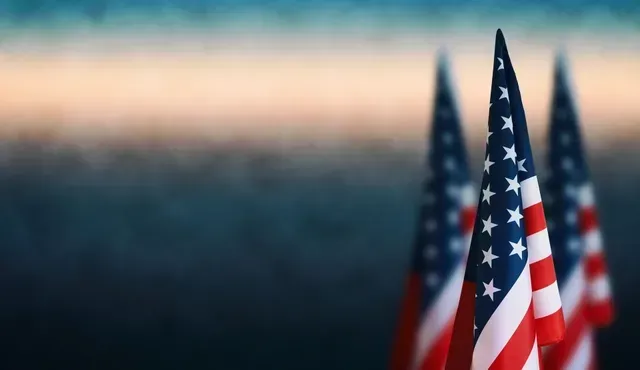 Three American flags with blurred background in red, white, and blue