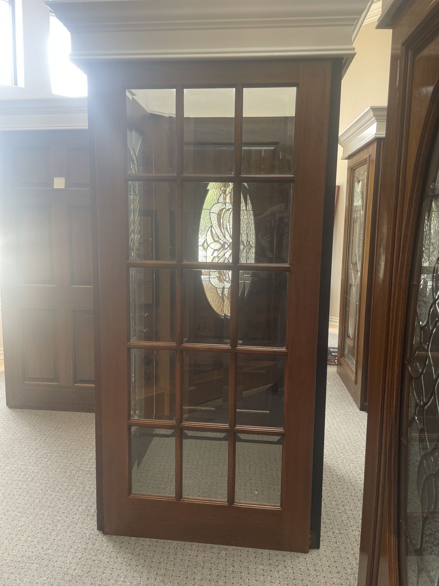 Wooden glass-front cabinet with mirrored back in a showroom or storage room