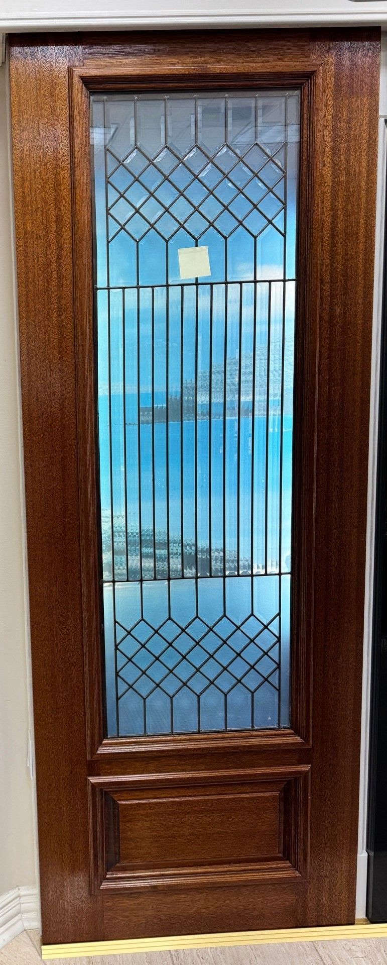 Wooden front door with decorative glass panels and a brass mail slot
