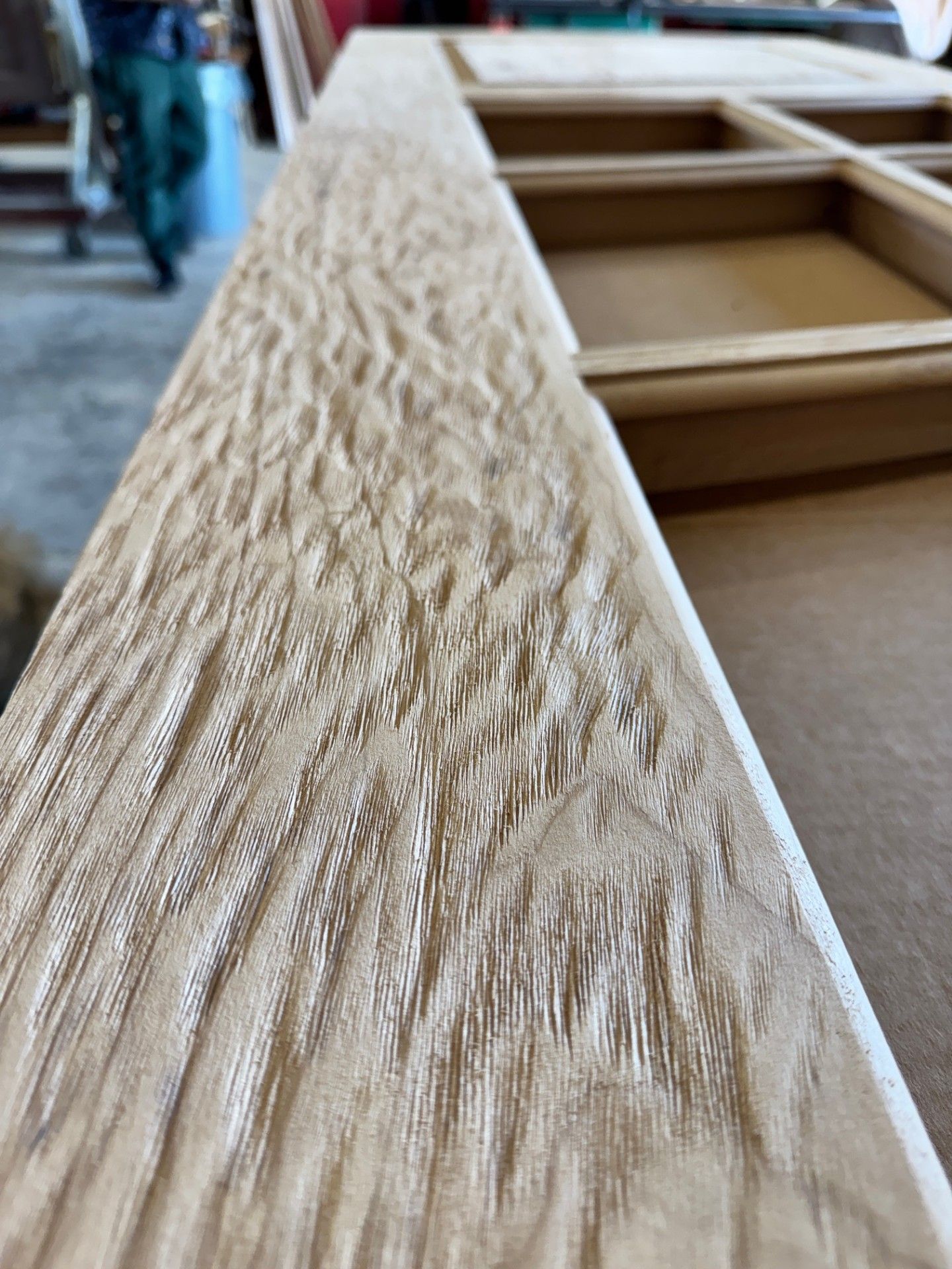 Close-up of a textured wooden board on a cabinet frame in a workshop or furniture store