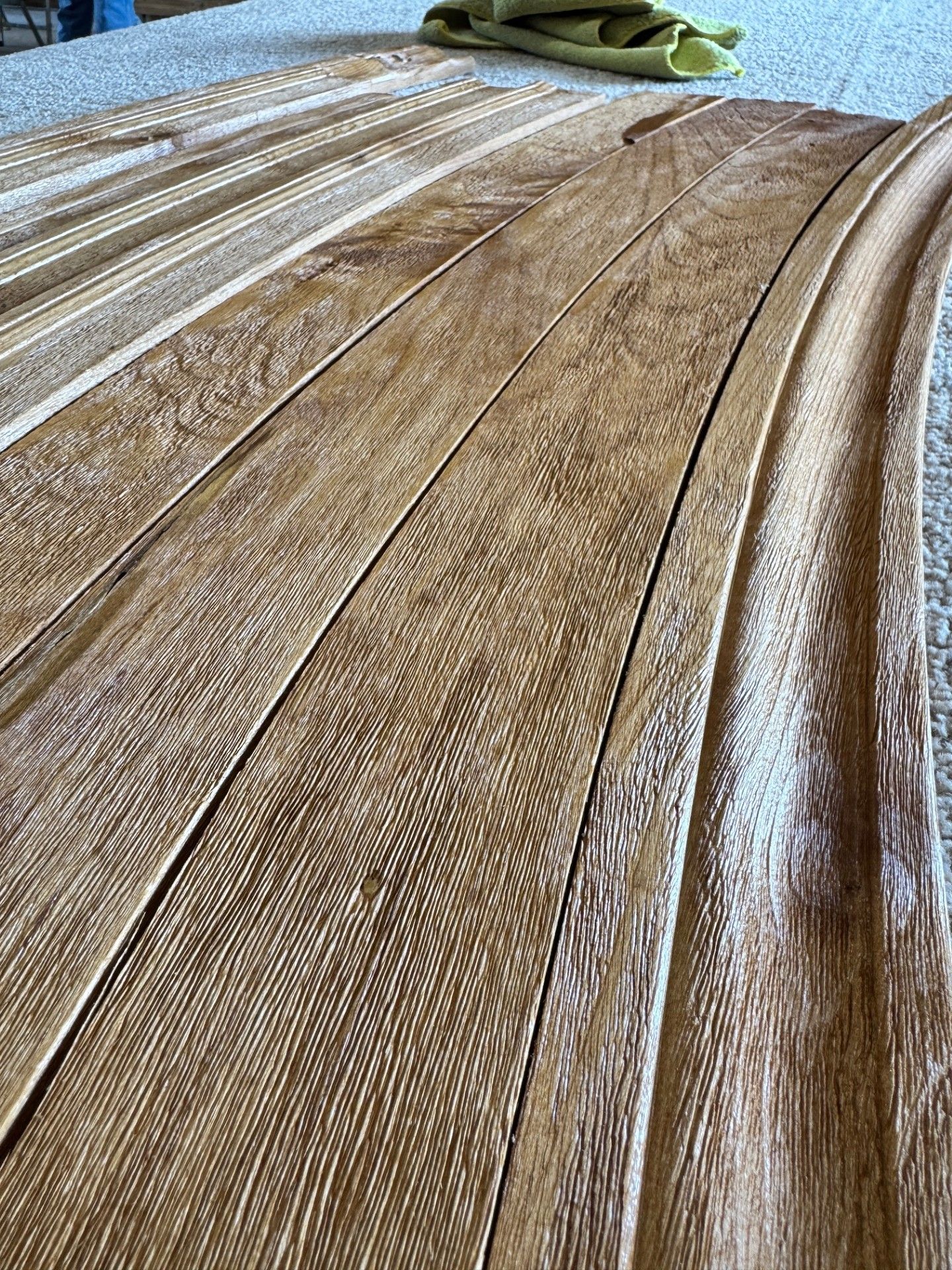 Close-up of a brown textured wooden floor with a small green cloth at the top edge