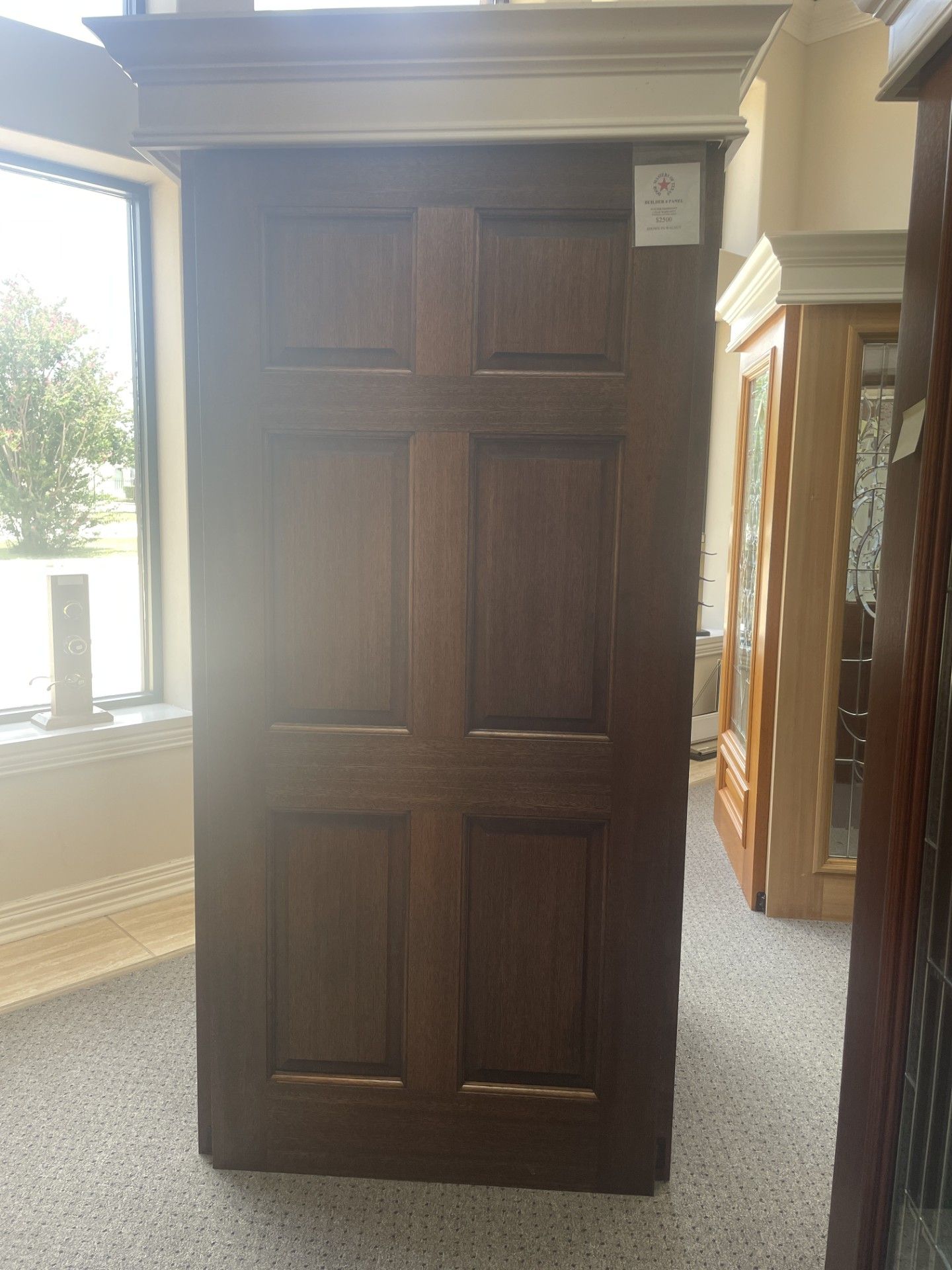 Dark wooden cabinet or wardrobe in a bright room near a window and another cabinet.