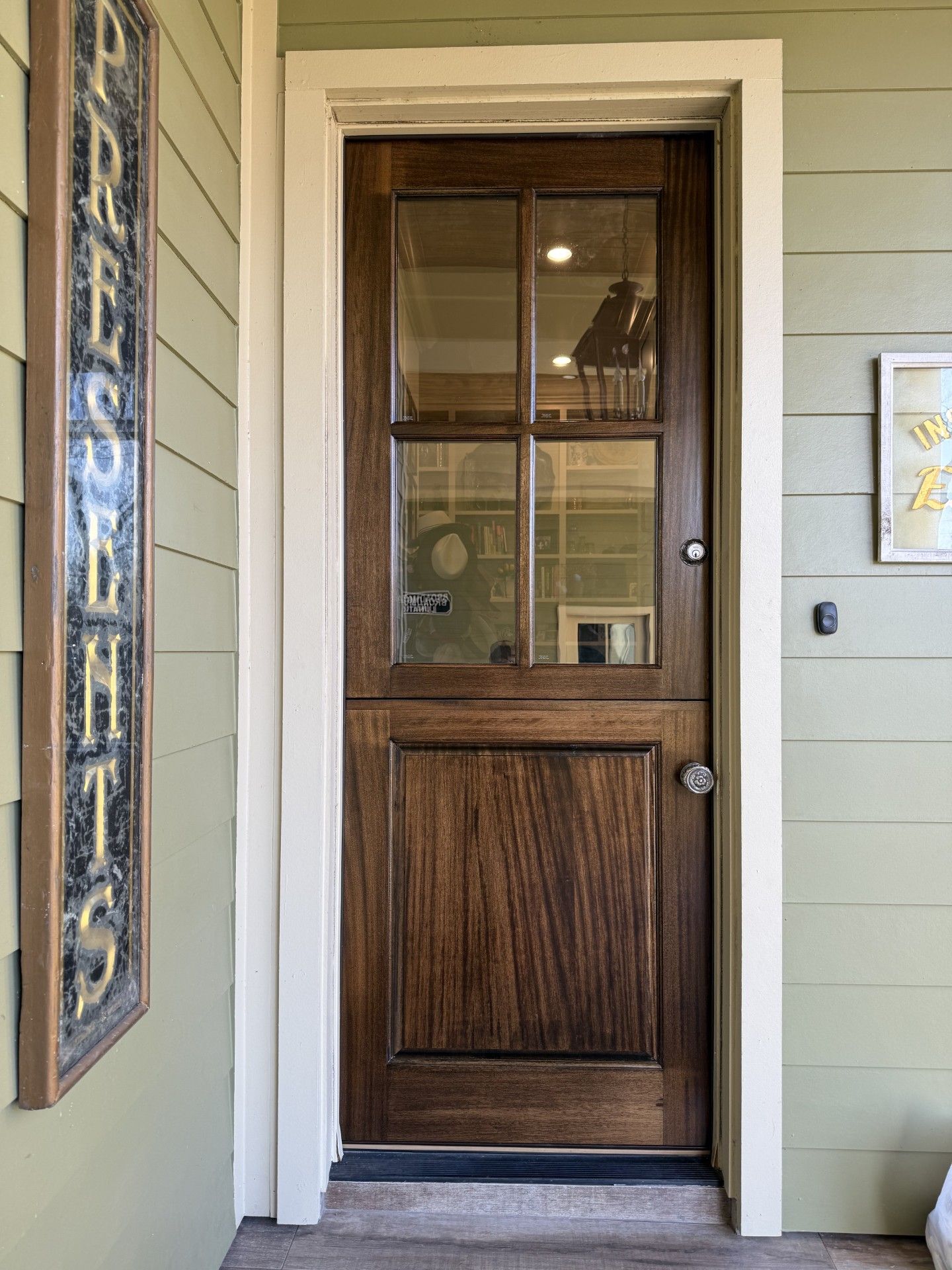 Wooden front door with glass panels in a beige house entryway