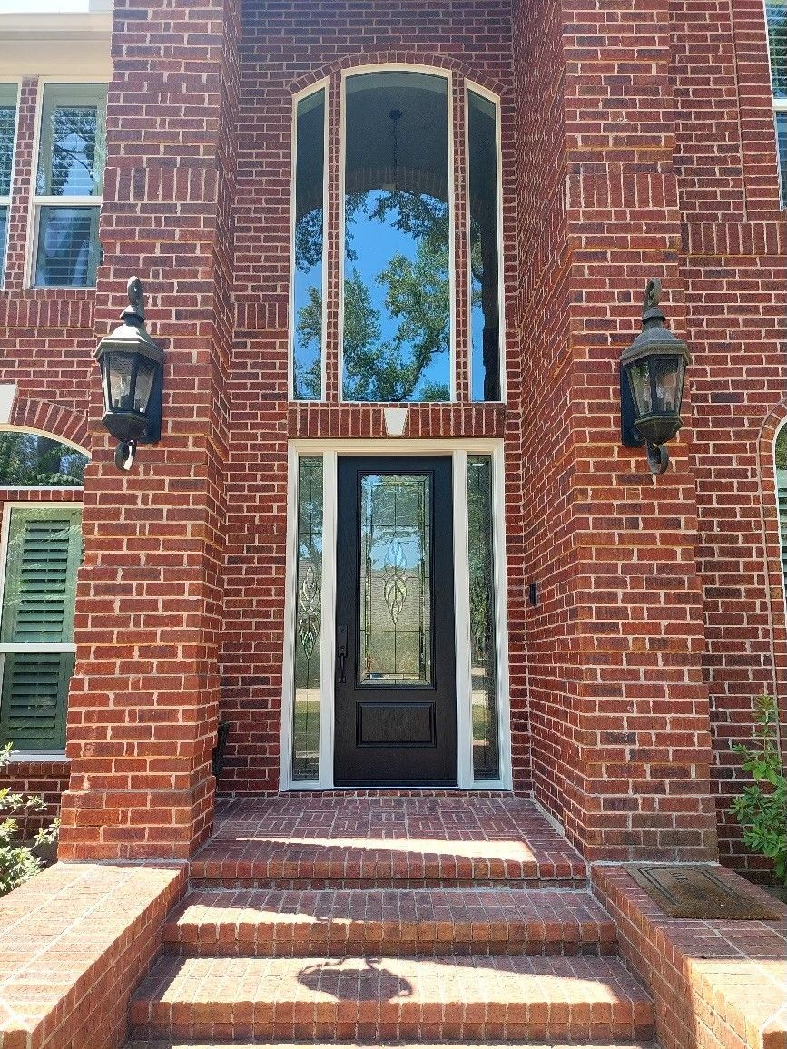 Brick building entrance with steps, open doorway, and hanging lanterns