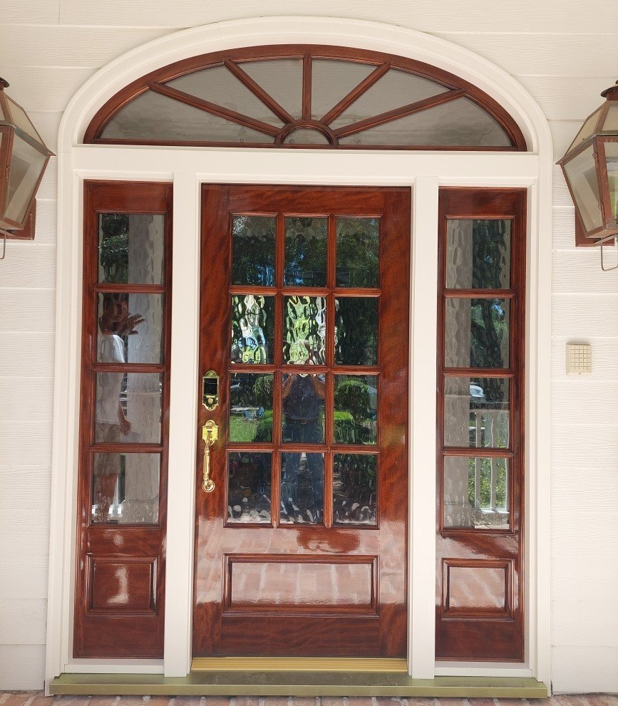Front entrance with a wooden glass door, sidelights, and an arched transom window