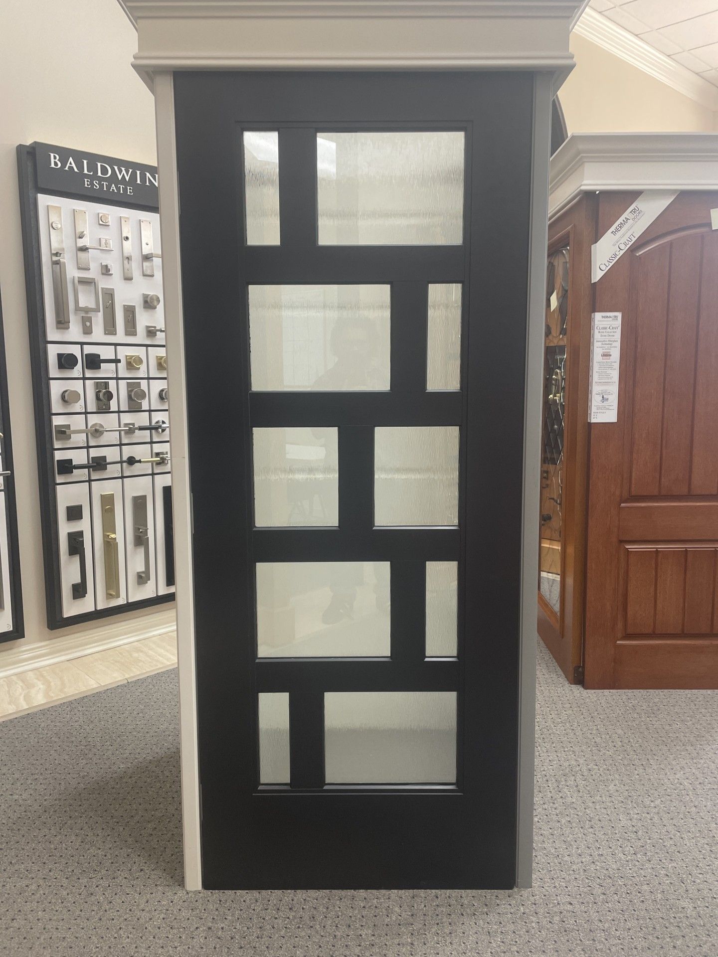 Black display panel with rectangular window cutouts in a showroom or museum exhibit area