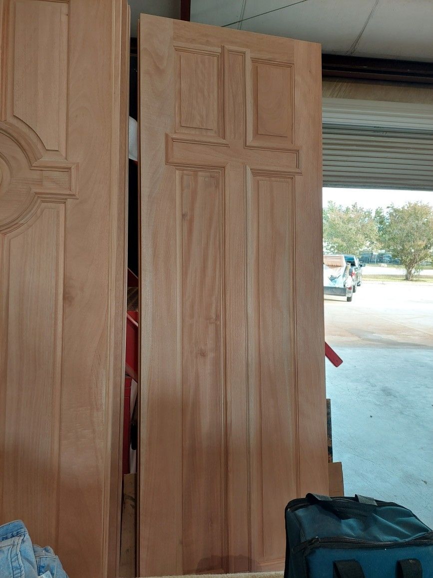Wooden doors opened to a bright street outside, with a black bag at the bottom right.