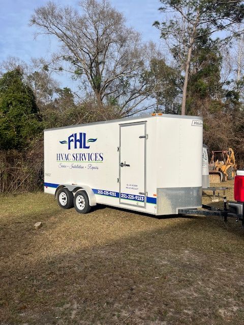 White FHL Event Rentals trailer parked on grass with trees in the background
