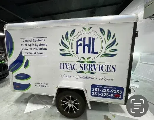 White HVAC service trailer with FHL logo, blue lettering, and phone numbers parked outdoors