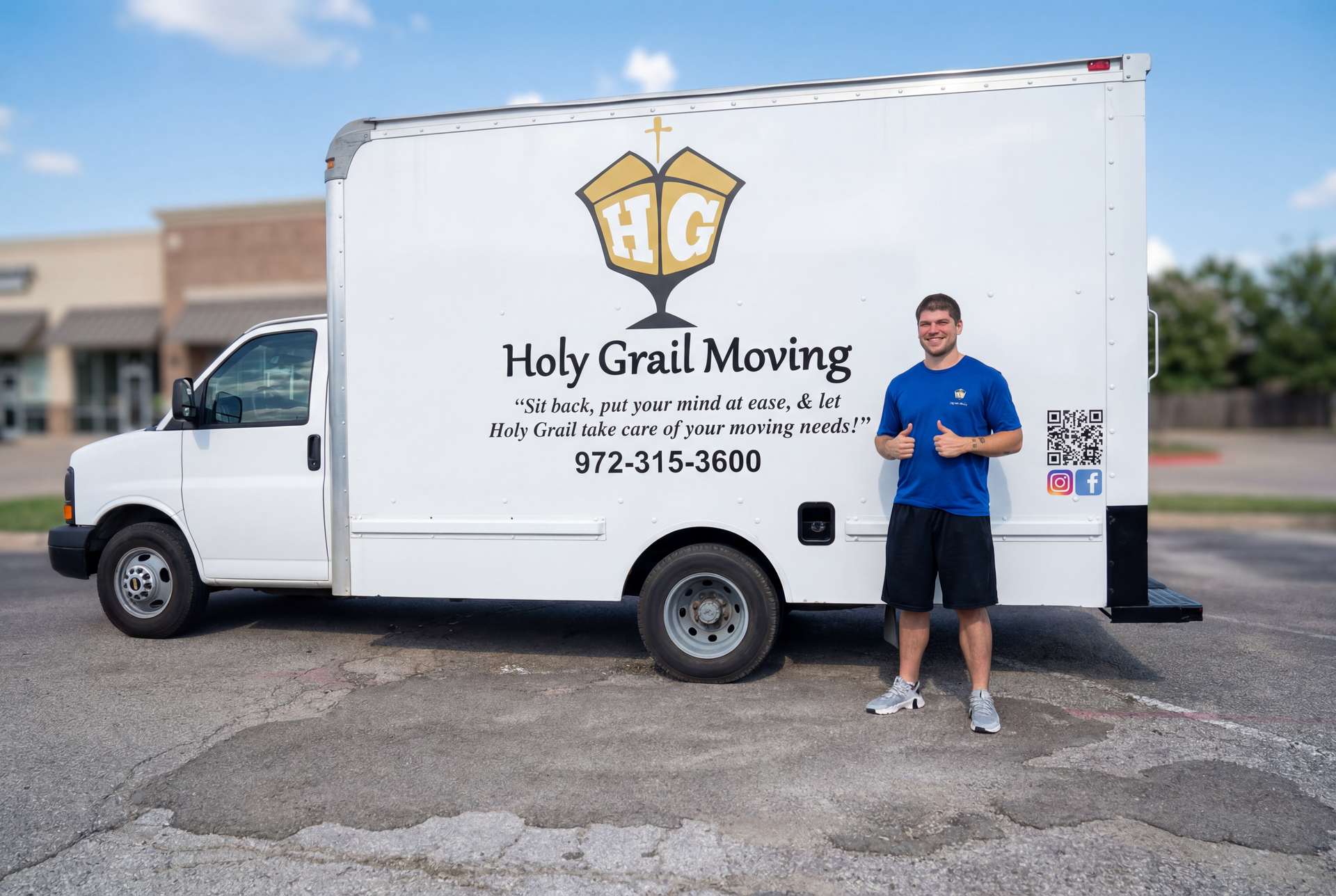 Holy Grail Moving truck with logo and phone number, man standing beside it in a parking lot