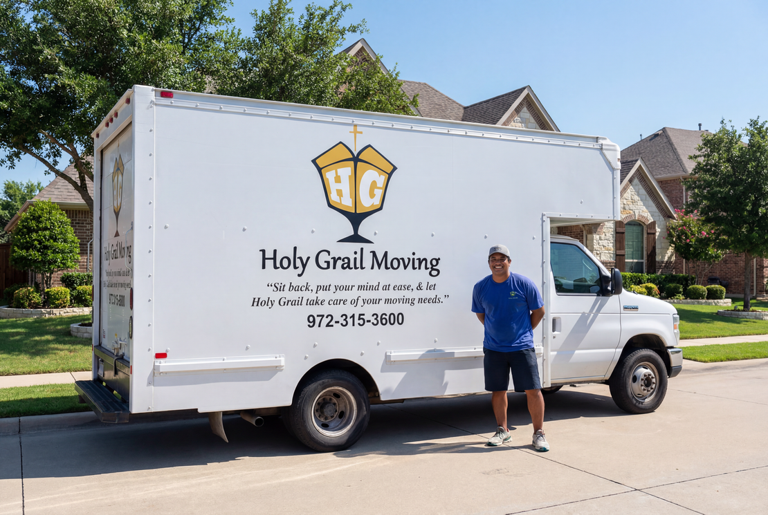 Holy Grail Moving truck parked on a street with a man standing beside it in a suburban neighborhood.