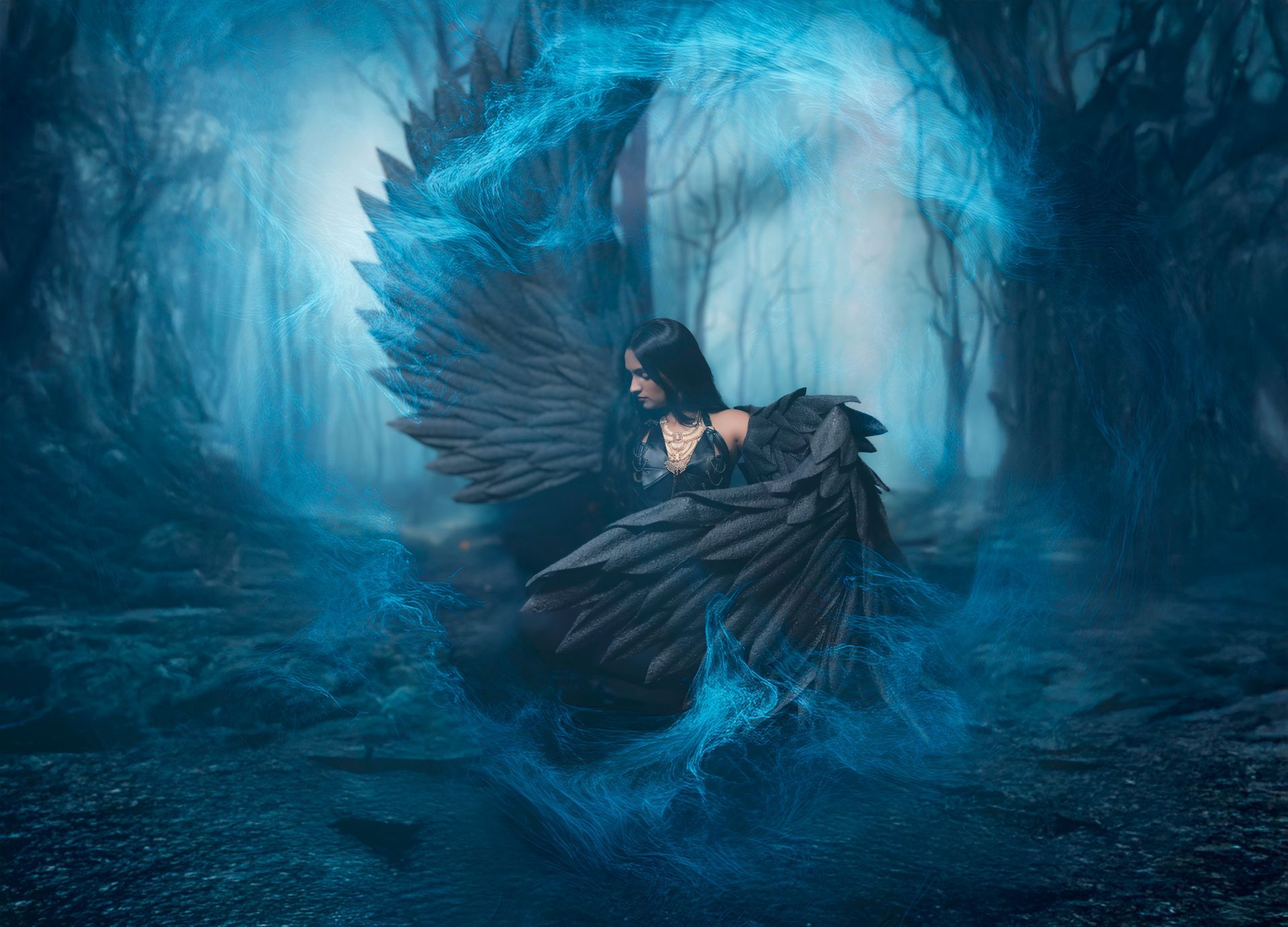 Woman with dark wings, surrounded by blue glowing energy in a dark forest.
